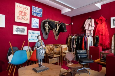 A view of a museum with red velvet walls and various objects owned by Sophie Calle.