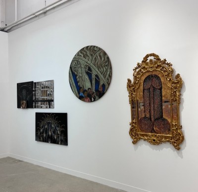 Several paintings in ornate frames on a white wall.