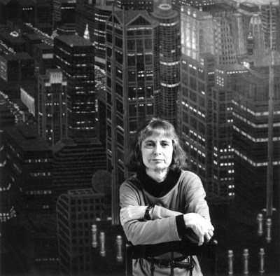 A black and white image of a woman in front of a city.