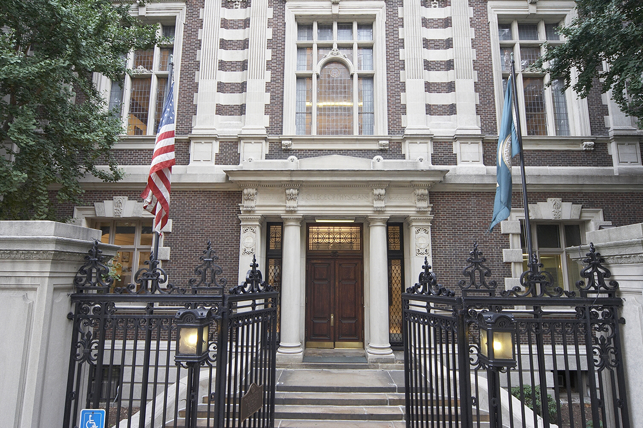 A collegiate Philadelphia building with an American and a Pennsylvania flag in front