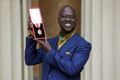 A man in a blue suit holding a medal inside a case.