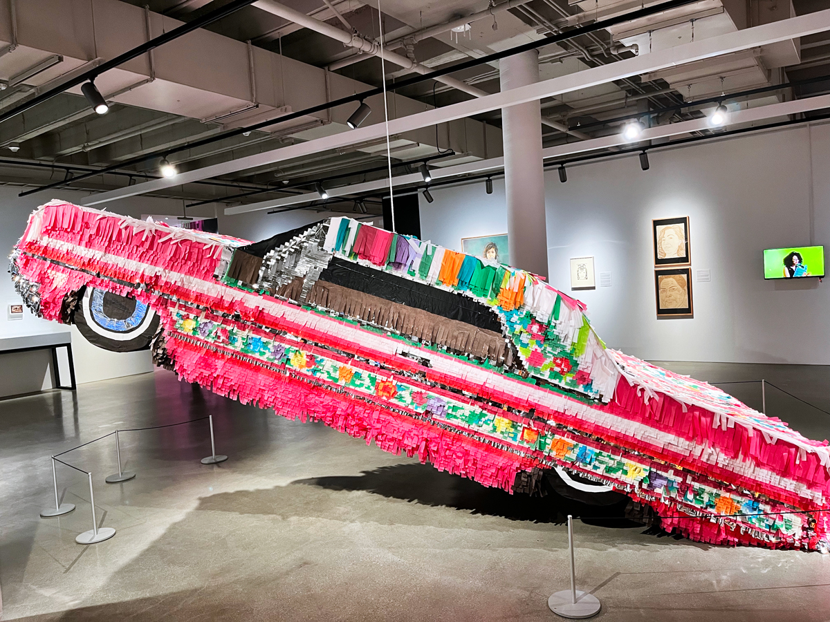 A large-scale piñata in the shape of a pink low-rider. 