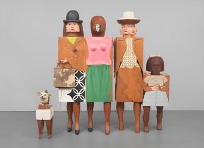 A sculpture showing several abstracted woman and a child, along with a dog. Each figure's body is abstracted into a cube that is painted with their dresses. Their faces are highly stylized, with some appearing to have multiple heads.
