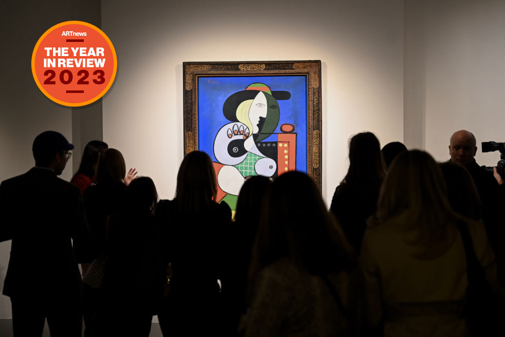 A crowd is gathered in front of a Pablo Picasso painting.